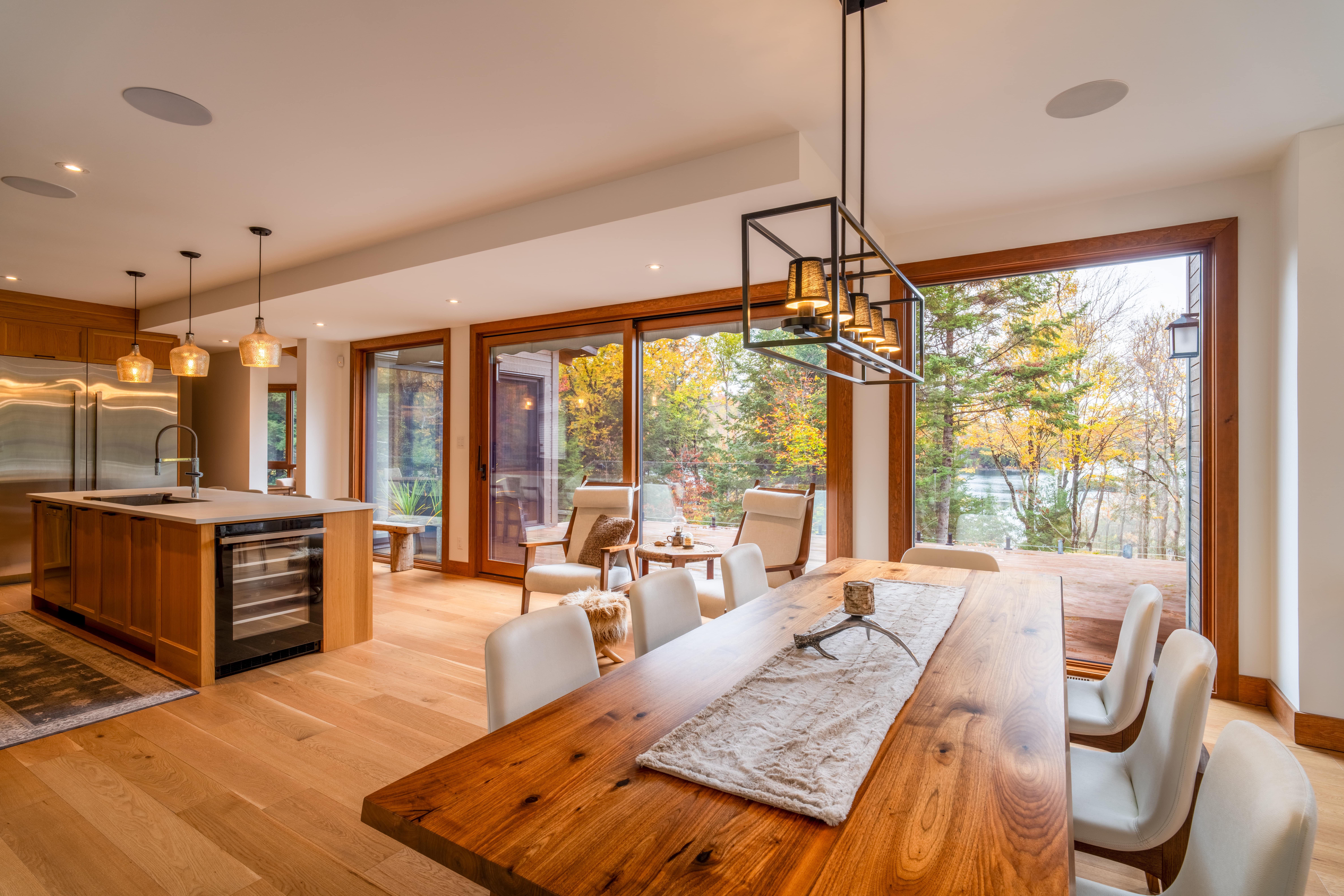 Mid-century kitchen and dining room with wooden sliding doors overlooking a lake view.